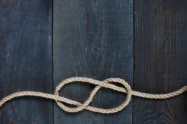 Photo knot of rope on the wooden background