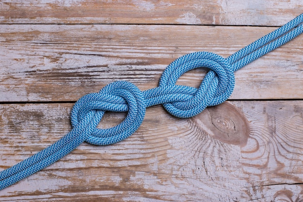 Foto nodo su una corda su uno sfondo di legno.