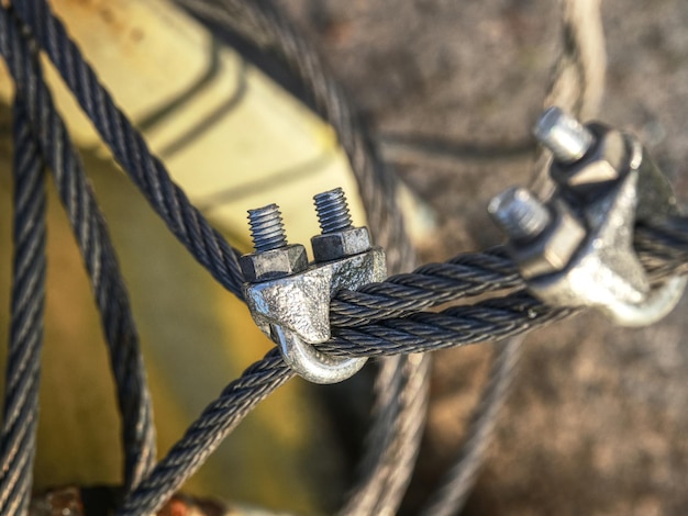 Photo knot of steel rope stainless steel turnbuckle and sling steel in base bolt anchor eye in ground