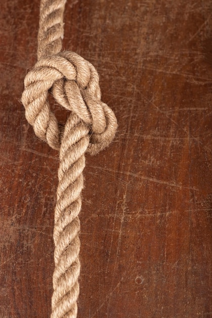 Knot on wood rope with reef knot on wood texture
background