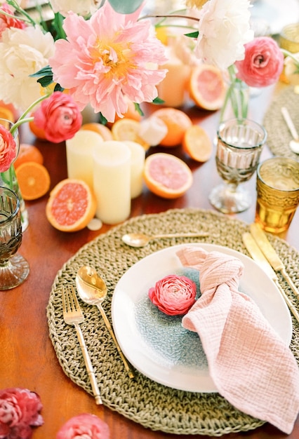 Knotted napkin lies on a plate next to a flower on a mat on a festive table