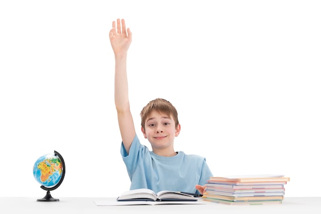 Knowitall boy raised his hand high in class Portrait of schoolboy with notebooks and textbook Isolation on white background Excellent student