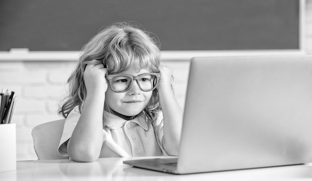 Knowledge day concept of online education nerd kid in glasses\
with laptop september 1