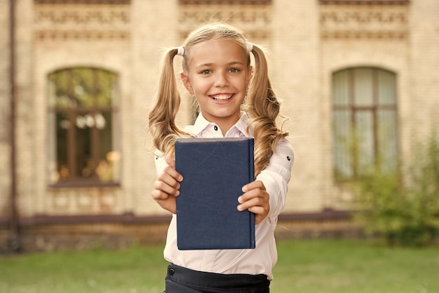 Knowledge day Ready for lessons Secondary school student Cute smiling small child hold book Adorable little girl school student Study language School education concept Cute little bookworm