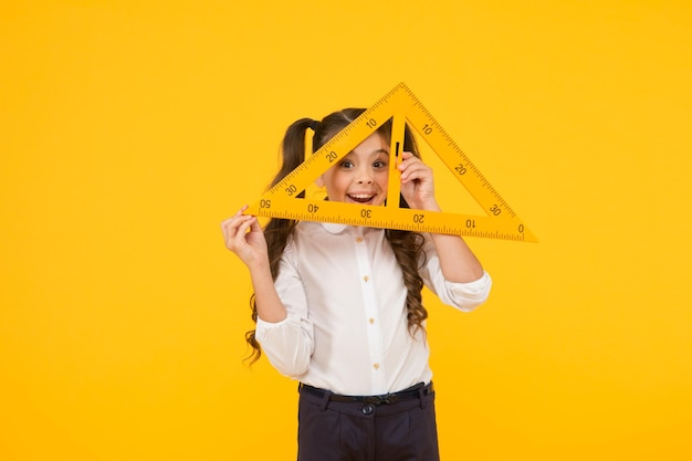 Knowledge day schoolgirl school uniform hold big ruler geometry school lesson triangle right angle math stem architecture faculty measuring equipment kid cute school student study mathematics