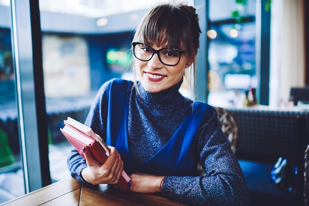 knowledge and education portrait of cheerful caucasian hipster girl in stylish optical spectacles