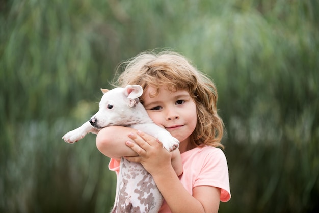 Foto knuffel vrienden gelukkig kind en hond knuffelt haar met tederheid glimlachend