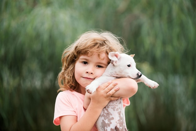 Knuffel vrienden Gelukkig kind en hond knuffelt haar met tederheid glimlachend