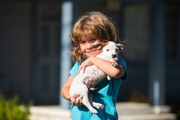 Knuffel vrienden, kind knuffelen hond. Gelukkig kind en puppy knuffels met tederheid glimlachen.