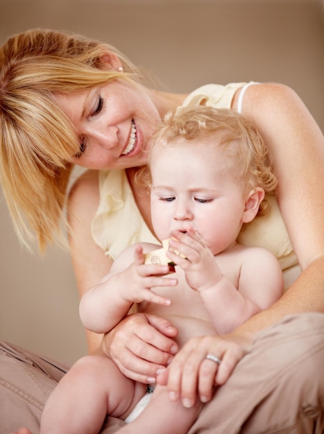 Knuffelen liefde en moeder met baby voor het spelen van spelletjes of het binden in hun huis samen Gezinsgezicht en ouder omhelzen jongen kind in een woonkamer plezier met bouwstenen speelgoed of leren