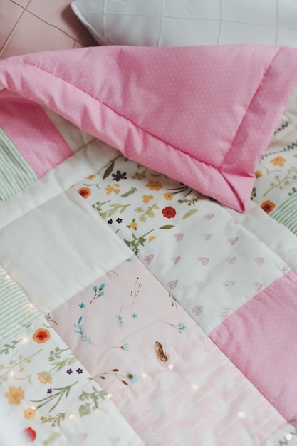 Knus babybedje met roze patchwork dekentje