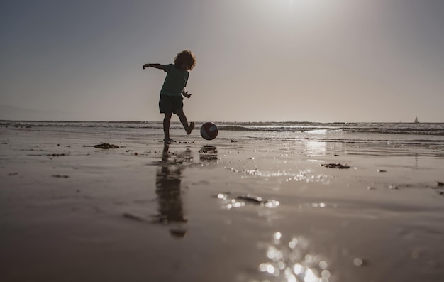 Kod voetbal of voetbal op het strand op zomervakantie, silhouet bij zonsondergang.