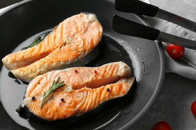 Foto koekenpan met heerlijke zalmsteaks op tafel