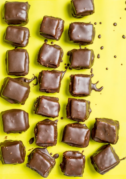 Koekjes in chocoladesuikerglazuur op een gele achtergrond.