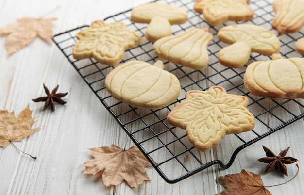 Koekjes in de vorm van pompoen en bladeren op rustieke houten ondergrond