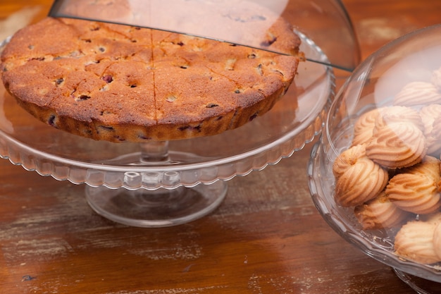 Koekjes in een glazen vaas en een ronde taart