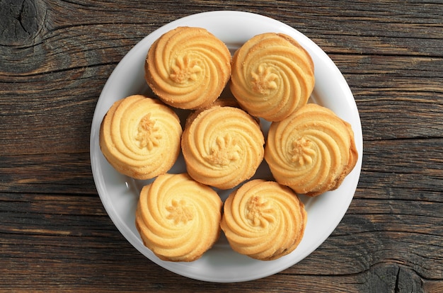 Koekjes met gekarameliseerde melk vullen plaat op een houten ondergrond, bovenaanzicht