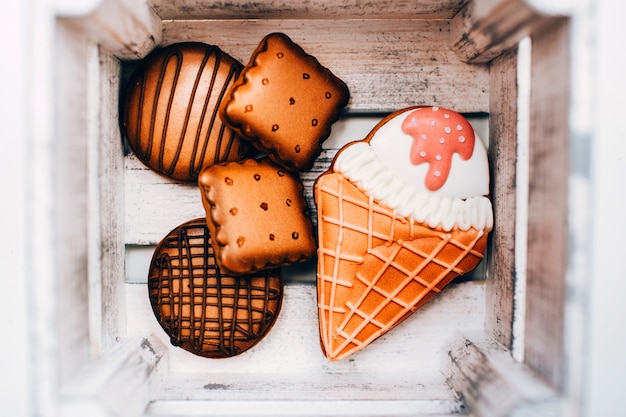 Koekjes met keukenmastiek in een houten doos. ronde en vierkante koekjes. ijs in een wafelkegel.