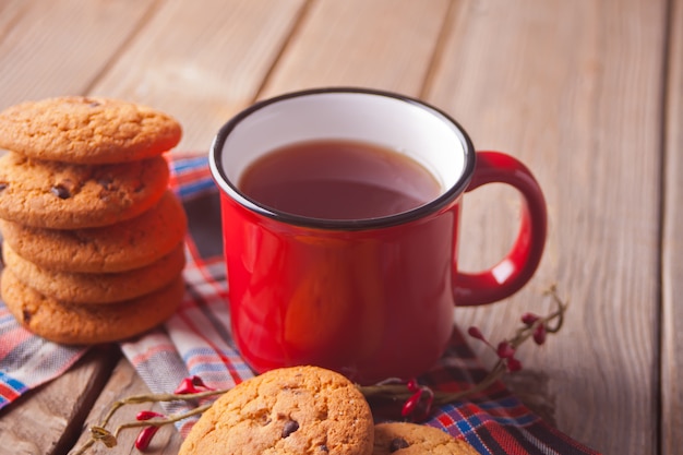 Koekjes met rode mok hete thee of koffie houten lijst