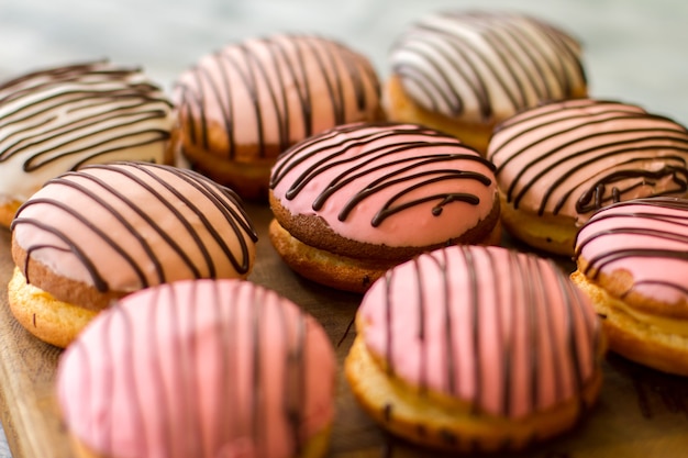 Koekjes met roze suikerglazuur. Gedecoreerde koekjes op een houten bord. Lekkere bushcakes als toetje. Beste snoep voor een lage prijs.