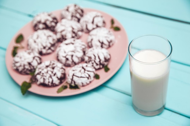 Koekjes op blauwe houten tafel in een bord met glas melk