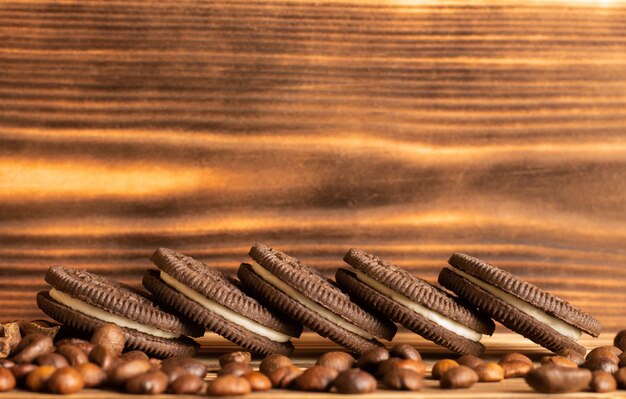 Koekjes op een bruine tafel van een verbrande boom met koffiebonen verspreid over de tafel.