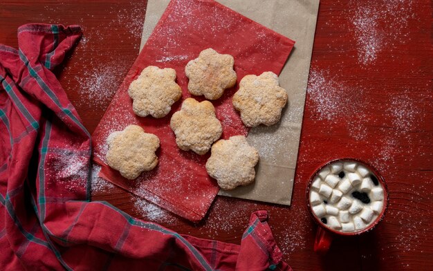 Koekjes op rode houten tafel met rode kop koffie en boodschappentas, leveringsconcept.