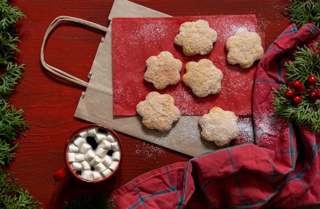 Koekjes op rode houten tafel met rode kop koffie en boodschappentas, leveringsconcept.