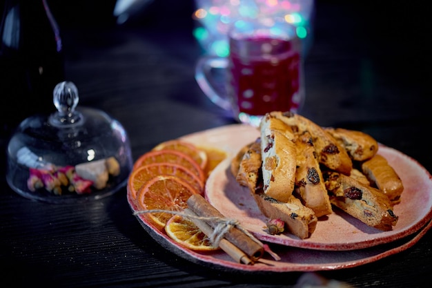 Koekjesbiscotti op een donkere achtergrond Een glas rode wijn of glühweinKerstslinger