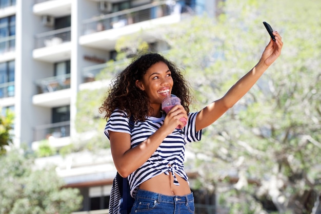 Koele jonge Afrikaanse Amerikaanse vrouw die selfie in openlucht neemt