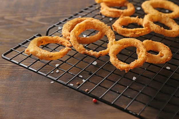 Foto koelrek met gebakken gepaneerde uienringen op houten ondergrond