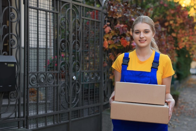 Koerier in uniform met pakjes in de buurt van privé huis buiten ruimte voor tekst