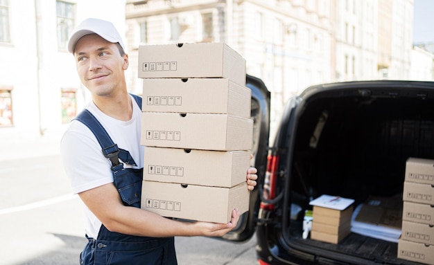 Koeriersbezorging een mannelijke chauffeur bezorgt bestellingen in dozen aan huis Uniform en pet voor een medewerker