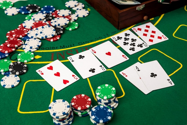 Koffer met dollars, speelkaart, pokerfiches op de groene pokertafel.