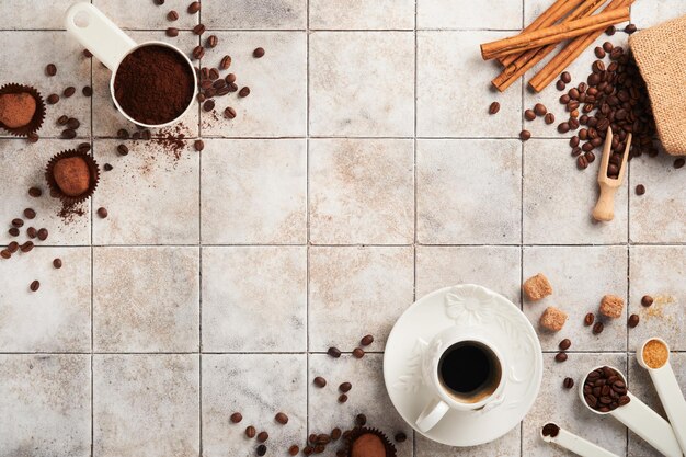 Koffie achtergrond Maatlepels met gemalen koffiebonen beker en zoete chocolade truffels op oude tegel gebarsten tafel achtergrond Voedsel achtergrond Bovenaanzicht met ruimte voor uw tekst