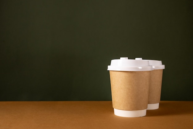 Koffie ambachtelijke papieren bekers met plaats voor logo op groene en bruine natuurlijke achtergrondkleur voor menu en