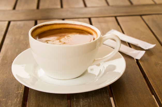 Koffie Americano in de witte kop op de houten tafel