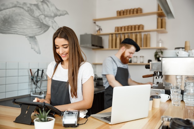 Koffie Business Concept - mooie Kaukasische barman Barista of manager Postorder in digitale tablet menu bij moderne koffie winkel.