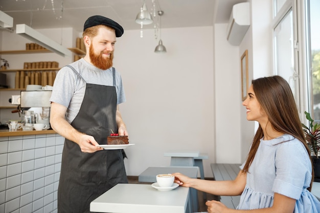 Koffie business concept ober of barman chocoladetaart geven en praten met blanke mooie dame in blauwe jurk bij coffee shop