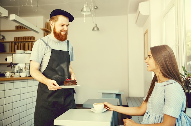 Koffie Business Concept Ober of barman chocoladetaart geven en praten met blanke mooie dame in blauwe jurk bij Coffee shop