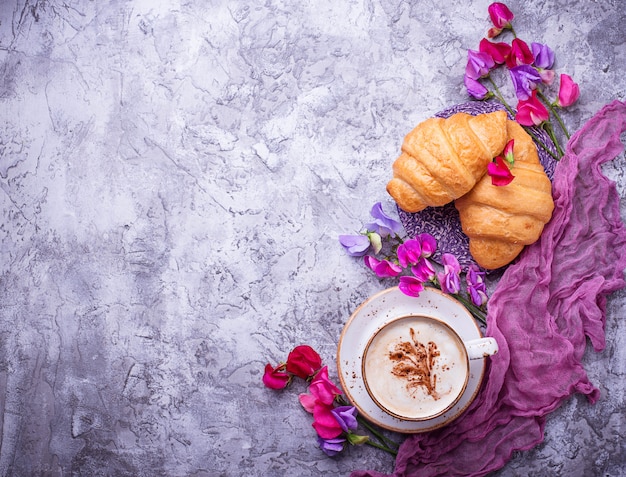 Koffie, croissants en bloemen. Plat leggen, bovenaanzicht