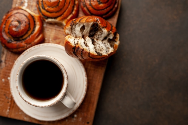 koffie en broodjes met maanzaad op een stenen achtergrond met kopie ruimte voor uw tekst