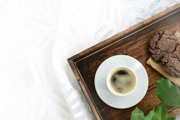 Koffie- en chocoladekoekjes op een houten dienblad bovenaanzicht kopieerruimte