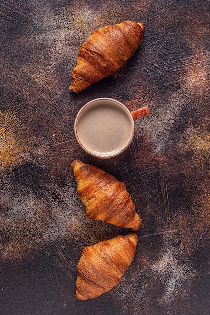 Koffie en croissant op stenen achtergrond. Frans ontbijt. Bovenaanzicht met kopie ruimte.