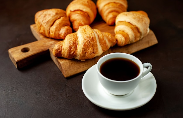 koffie en croissants op houten snijplank