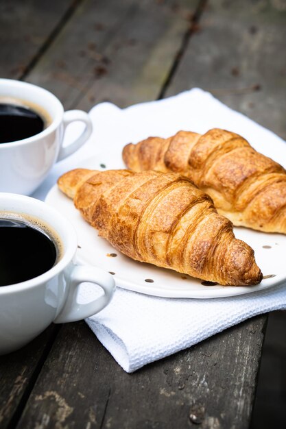 Koffie en croissants op oude rustieke houten tafel