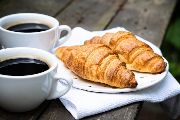 Koffie en croissants op oude rustieke houten tafel