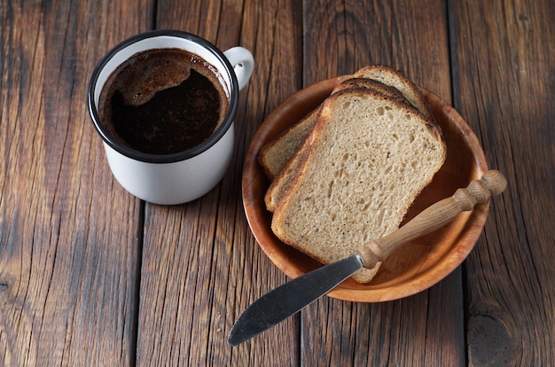 Koffie en gesneden roggebrood in kom op houten tafel