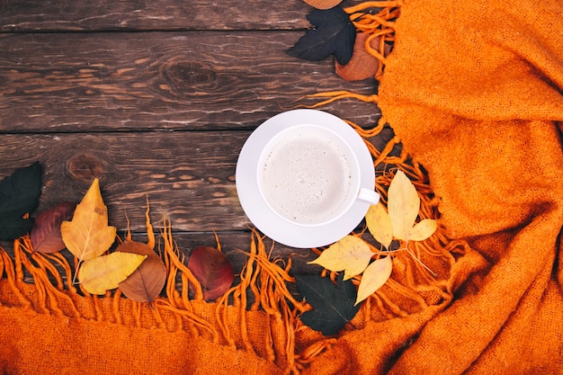 koffie en herfstbladeren op een houten ondergrond