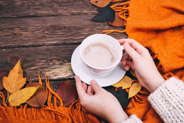 koffie en herfstbladeren op een houten ondergrond